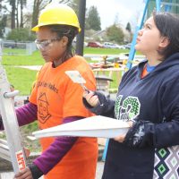 Painting tiny home shelter in the rain.