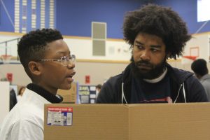 STEM Expo judge listens to a student presentation.
