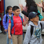 Students get hi-fives from TAF staff as they walk out of Boze for the summer